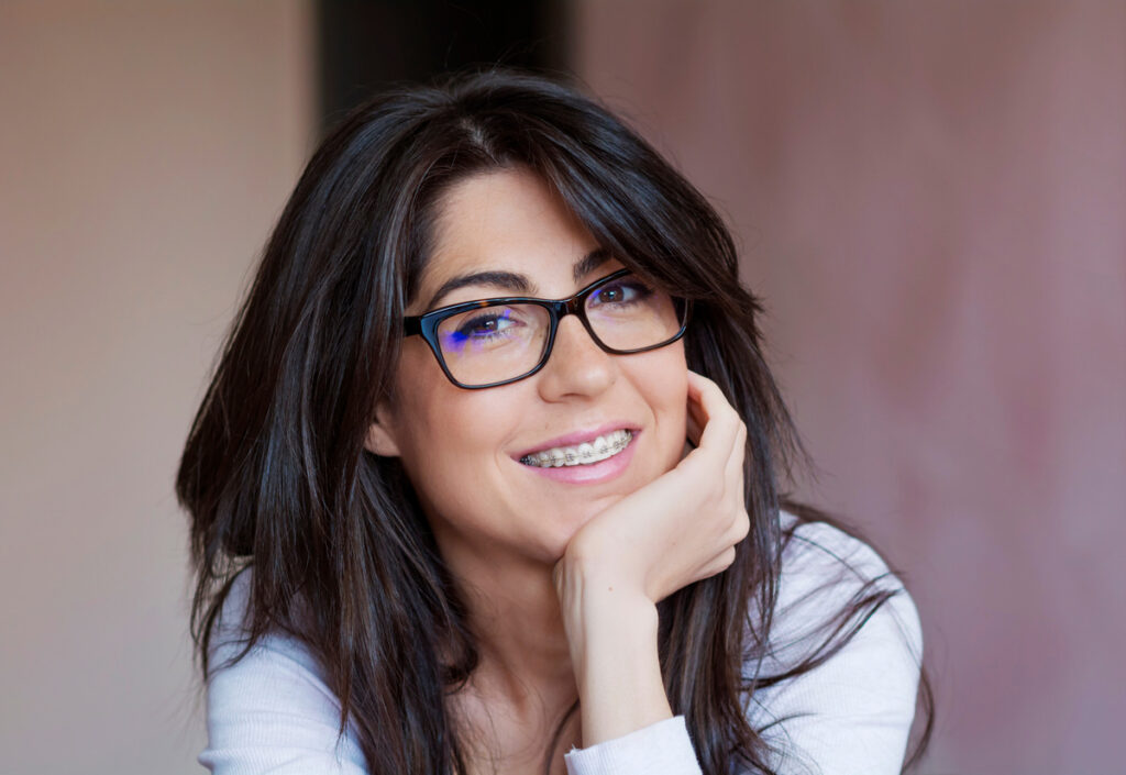 Portrait of a Beautiful Woman with Braces on Teeth. Orthodontic Treatment. Dental Care Concept