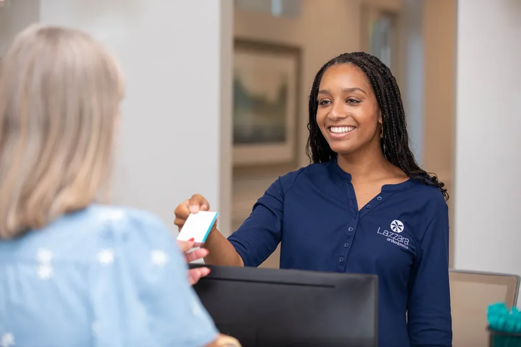 assistant handing appointment card to patient