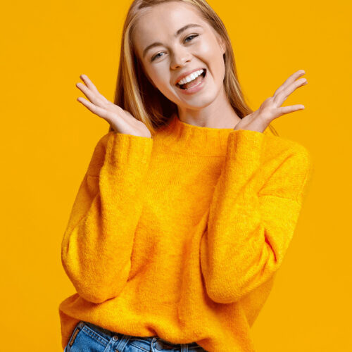 teen smiling in yellow sweater