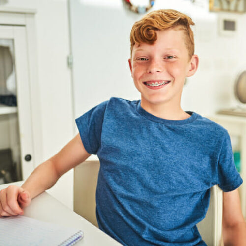 Portrait of a handsome young boy doing his homework at home