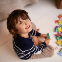 Portrait of an adorable little boy playing with colorful toy letters