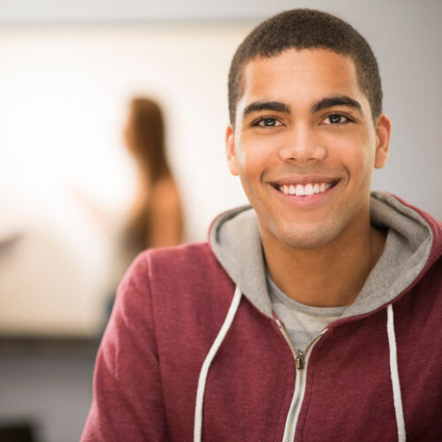 Male teen in maroon jacket smiling